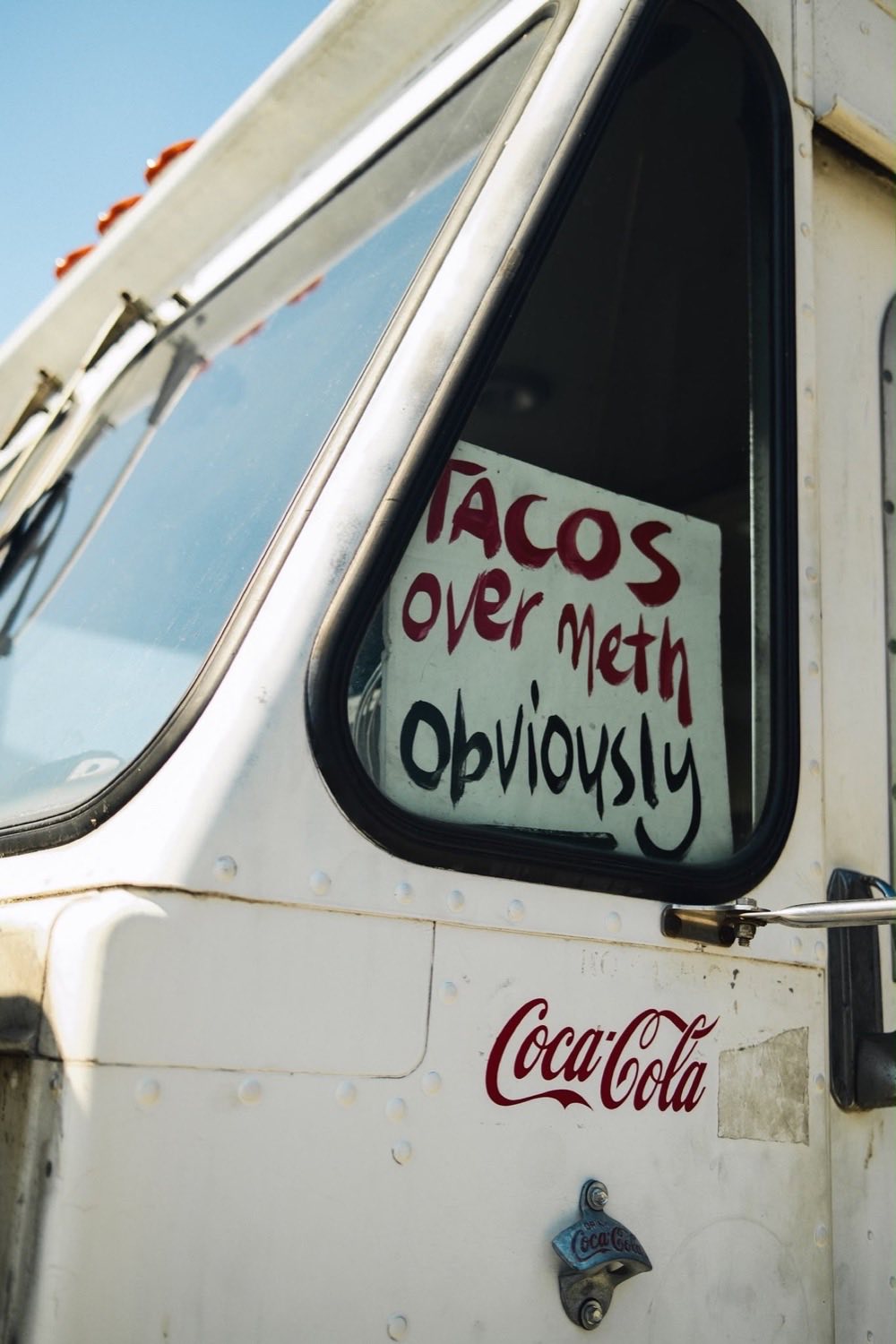A handwritten sign in the cab window reading Tacos over meth, obviously.