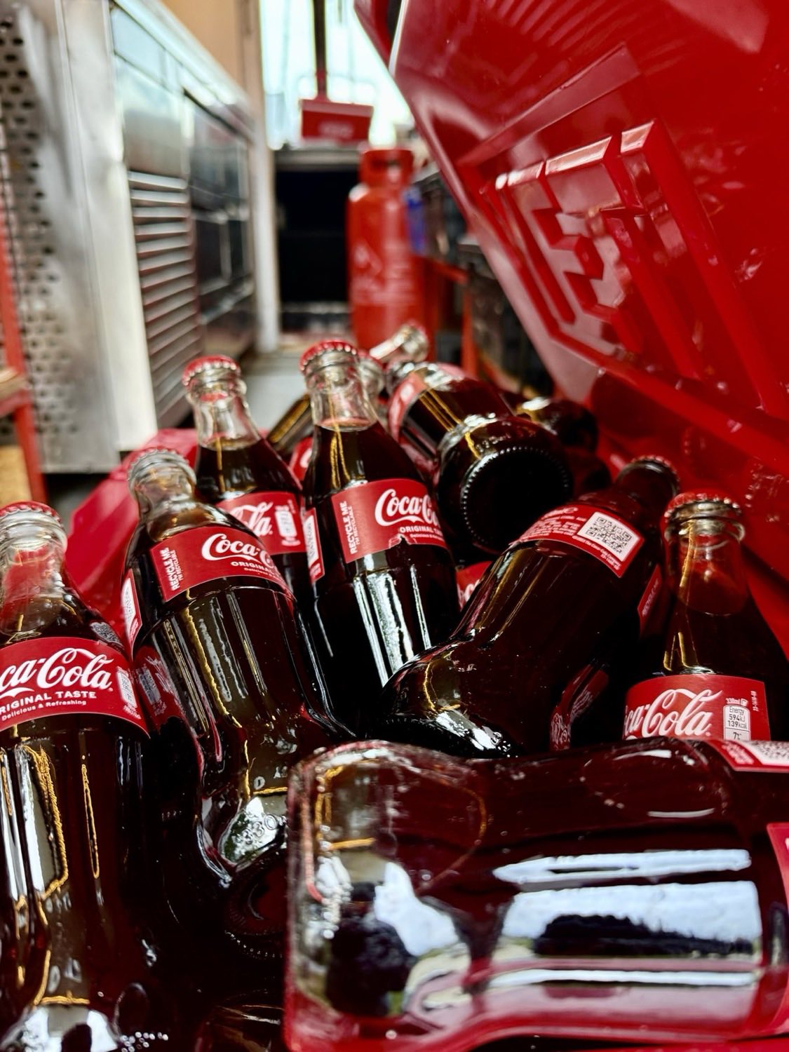 Glass bottles of Coca-Cola packed in a red crate on the truck.